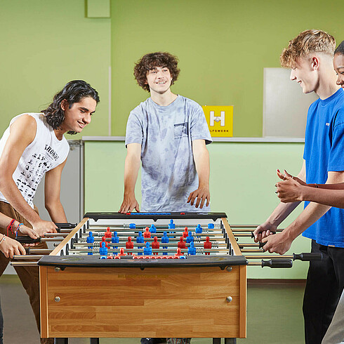 Jugendliche spielen Tischfussball