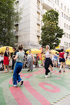 Menschen tanzen bei einem Straßenfest.